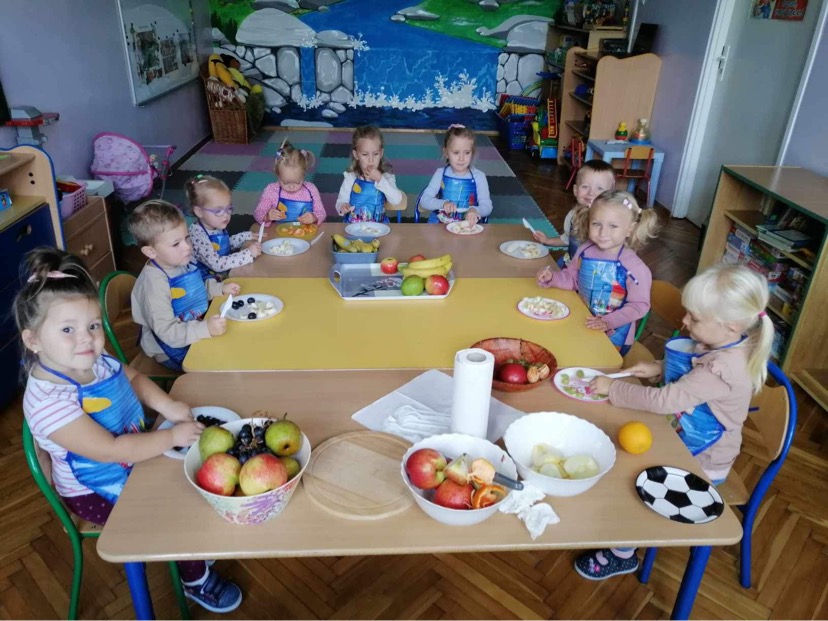 Przedszkolaki przygotowują owocową przekąskę.
